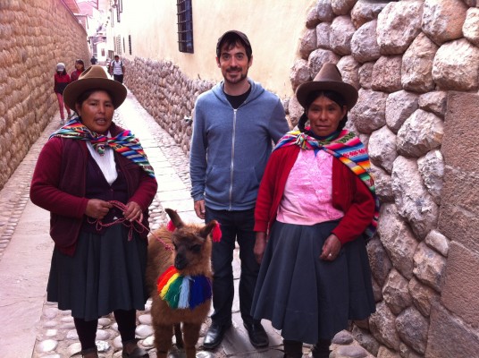 Posing with a baby alpaca and two local women
